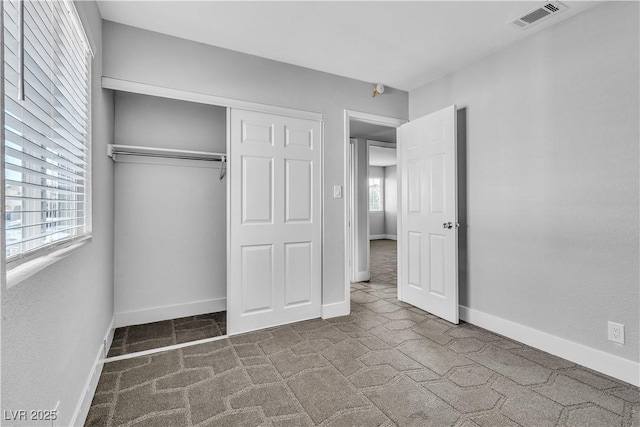 unfurnished bedroom featuring carpet flooring and a closet