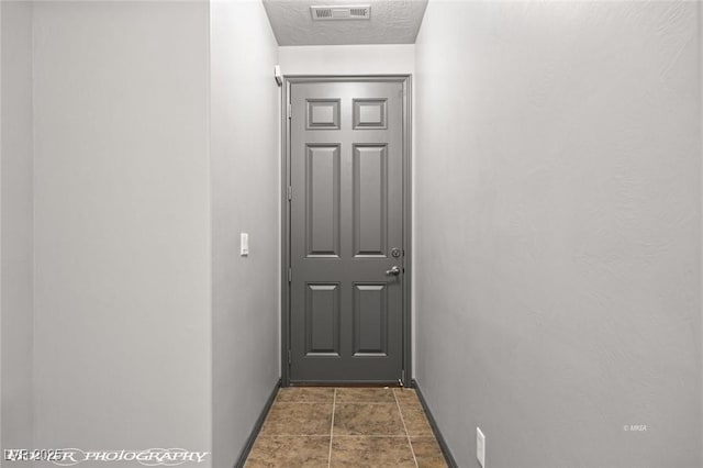 doorway to outside featuring a textured ceiling