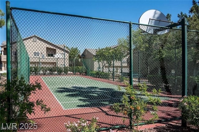 view of tennis court with community basketball court and fence