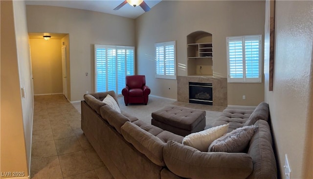 living room featuring light tile patterned floors, a healthy amount of sunlight, a fireplace, and ceiling fan