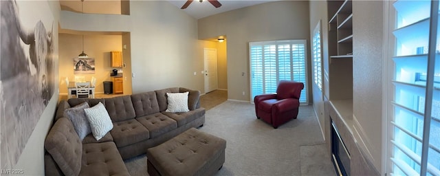 living area featuring vaulted ceiling, a ceiling fan, and light colored carpet