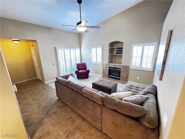 living room with built in shelves, a ceiling fan, plenty of natural light, and a premium fireplace