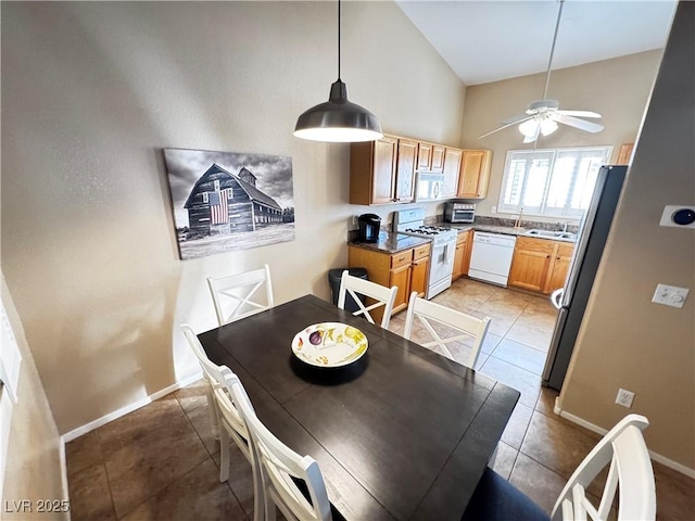 dining space with a ceiling fan, a toaster, baseboards, and light tile patterned floors