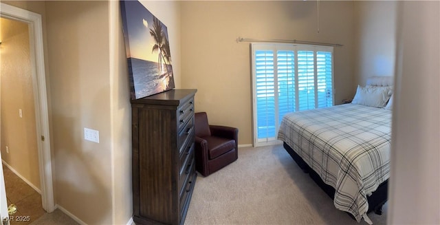 bedroom featuring light carpet and baseboards