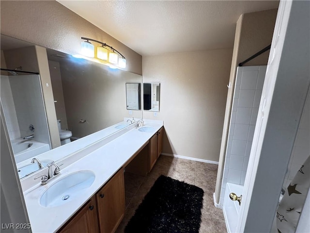 bathroom with double vanity, shower / washtub combination, a sink, and toilet