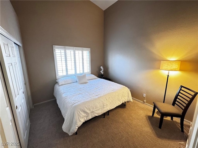 bedroom with carpet floors, baseboards, high vaulted ceiling, and a closet