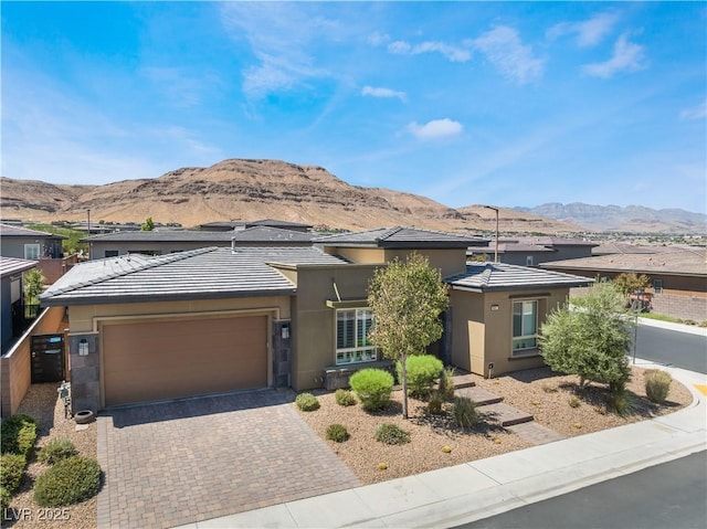 prairie-style home featuring a garage and a mountain view