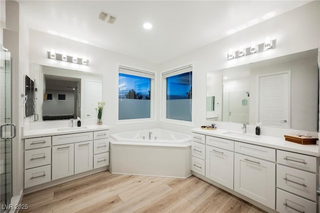 bathroom featuring vanity, plus walk in shower, and hardwood / wood-style floors