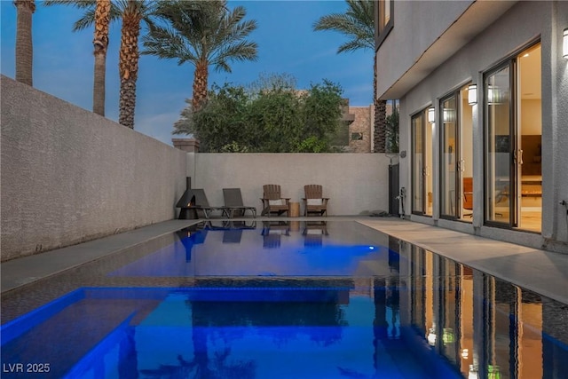 pool at dusk with a patio