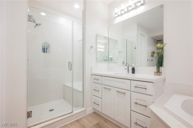 bathroom with vanity, hardwood / wood-style flooring, and separate shower and tub