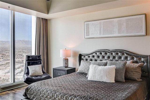 bedroom with hardwood / wood-style flooring and a mountain view