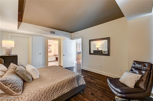 bedroom featuring ensuite bathroom and dark hardwood / wood-style flooring