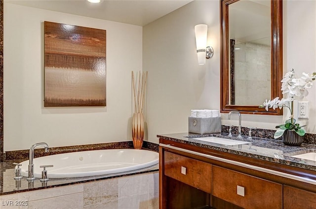 bathroom featuring tiled tub and vanity