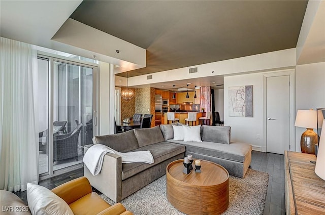 living room with hardwood / wood-style flooring and an inviting chandelier