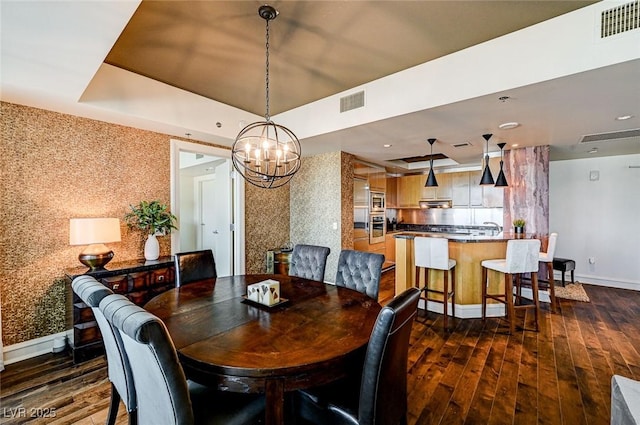 dining room with a tray ceiling and dark hardwood / wood-style floors