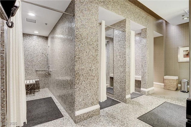 bathroom with tiled shower and tile patterned floors