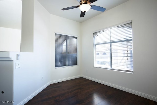 spare room with dark wood-type flooring and ceiling fan