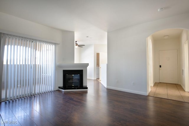 unfurnished living room featuring ceiling fan and dark hardwood / wood-style floors