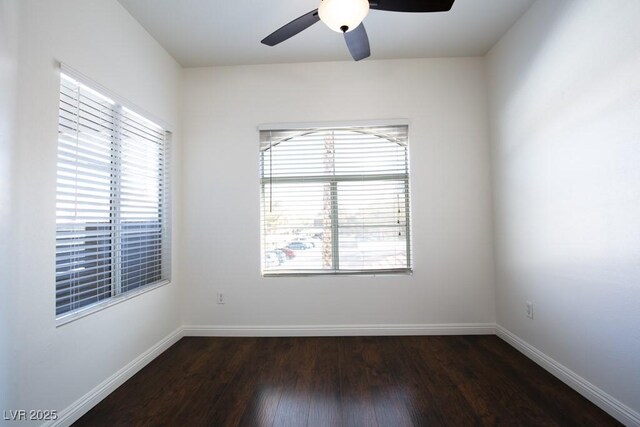 spare room featuring dark wood-type flooring and ceiling fan