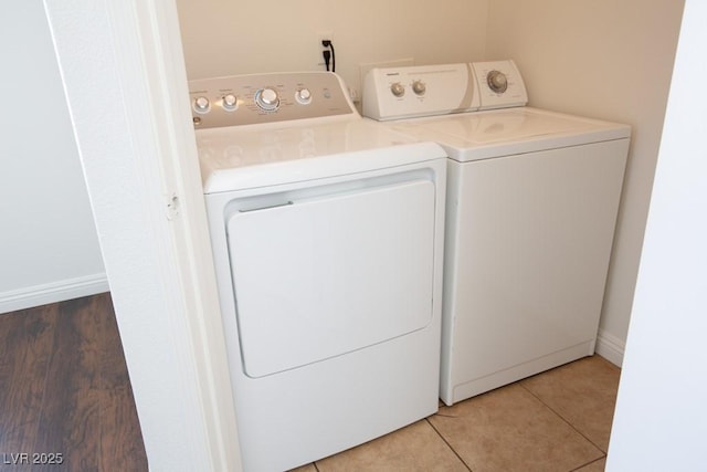 clothes washing area featuring tile patterned floors and washer and clothes dryer