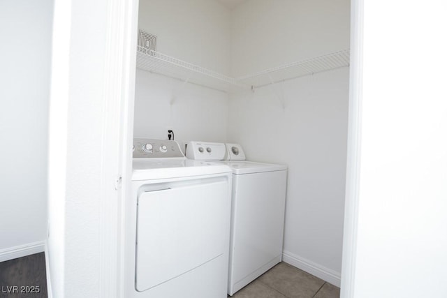 clothes washing area featuring tile patterned floors and washing machine and clothes dryer