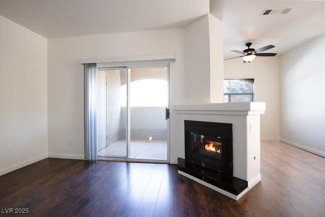 unfurnished living room with dark hardwood / wood-style flooring and ceiling fan