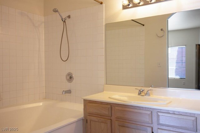 bathroom featuring tiled shower / bath combo and vanity