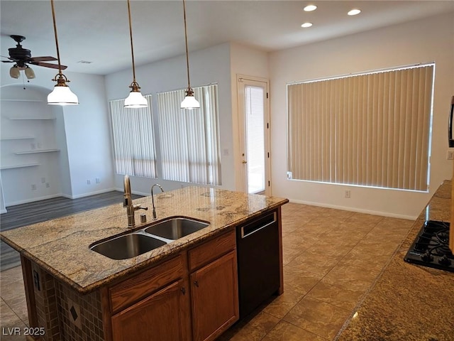 kitchen featuring sink, light stone counters, hanging light fixtures, a center island with sink, and dishwasher