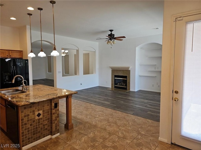 kitchen featuring stone countertops, decorative light fixtures, sink, ceiling fan, and black appliances