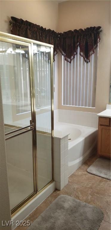 bathroom with vanity and shower with separate bathtub