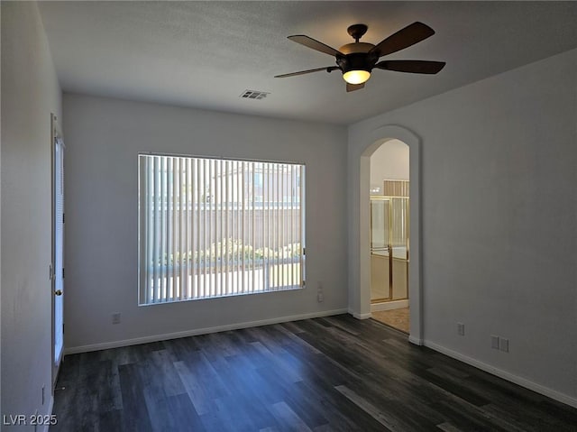 empty room featuring dark hardwood / wood-style flooring and ceiling fan