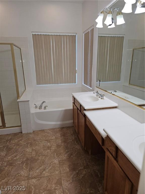 bathroom featuring an inviting chandelier, vanity, and independent shower and bath