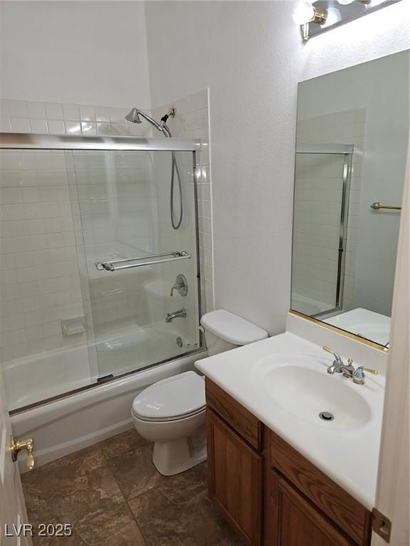 full bathroom with bath / shower combo with glass door, vanity, and toilet