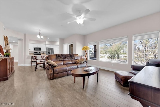 living room with ceiling fan and light hardwood / wood-style floors