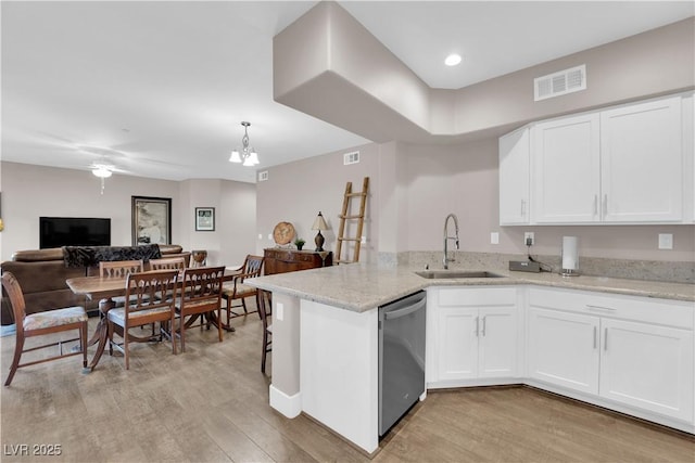 kitchen with dishwasher, sink, white cabinets, and kitchen peninsula