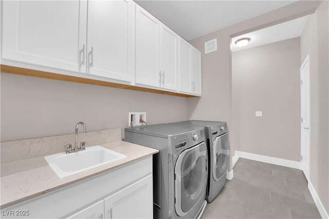 laundry room with sink, washer and clothes dryer, and cabinets