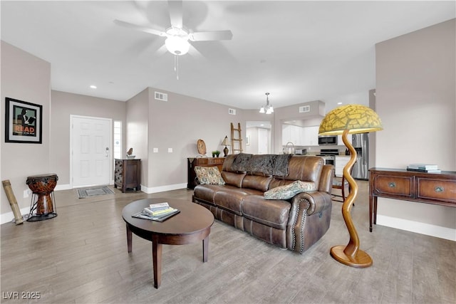 living room featuring sink, a chandelier, and hardwood / wood-style floors