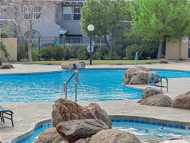 view of swimming pool with a hot tub