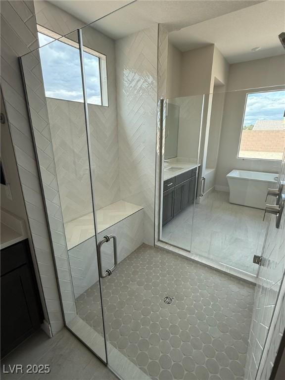 4630 Blushing Dawn Ave, Las Vegas, NV 89118 - bathroom with a shower stall, a freestanding bath, vanity, and tile patterned flooring