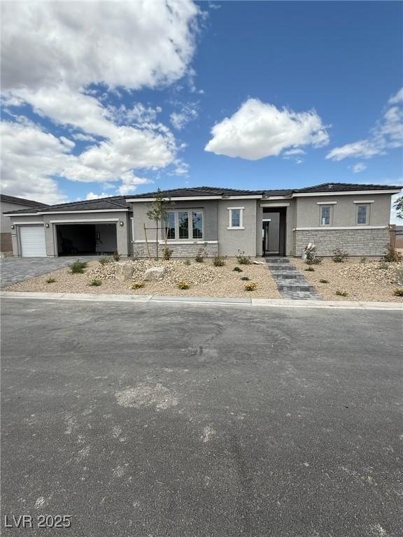 4630 Blushing Dawn Ave, Las Vegas, NV 89118 - view of front of home with stucco siding, a garage, driveway, and stone siding