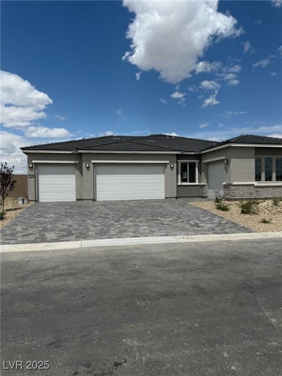 4630 Blushing Dawn Ave, Las Vegas, NV 89118 - view of front of home with stucco siding, a garage, and decorative driveway