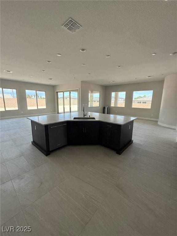 4630 Blushing Dawn Ave, Las Vegas, NV 89118 - kitchen featuring open floor plan, dishwasher, a sink, dark cabinetry, and light countertops