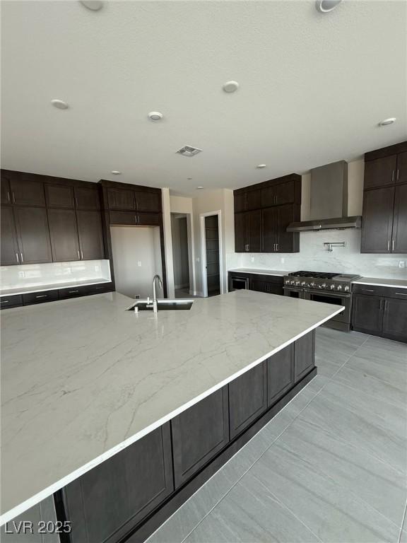 4630 Blushing Dawn Ave, Las Vegas, NV 89118 - kitchen featuring a sink, wall chimney exhaust hood, decorative backsplash, range with two ovens, and light stone counters