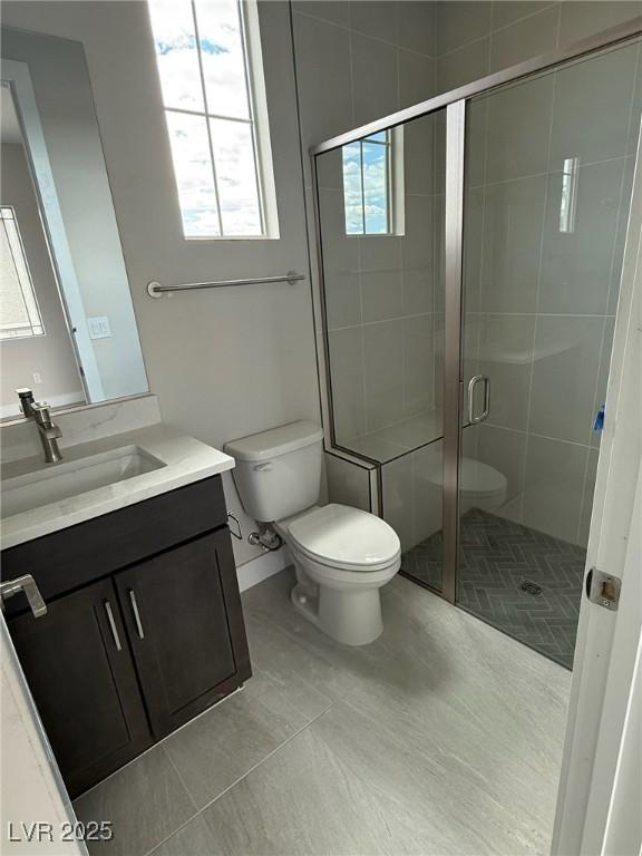 4630 Blushing Dawn Ave, Las Vegas, NV 89118 - bathroom featuring toilet, a stall shower, vanity, tile patterned floors, and baseboards