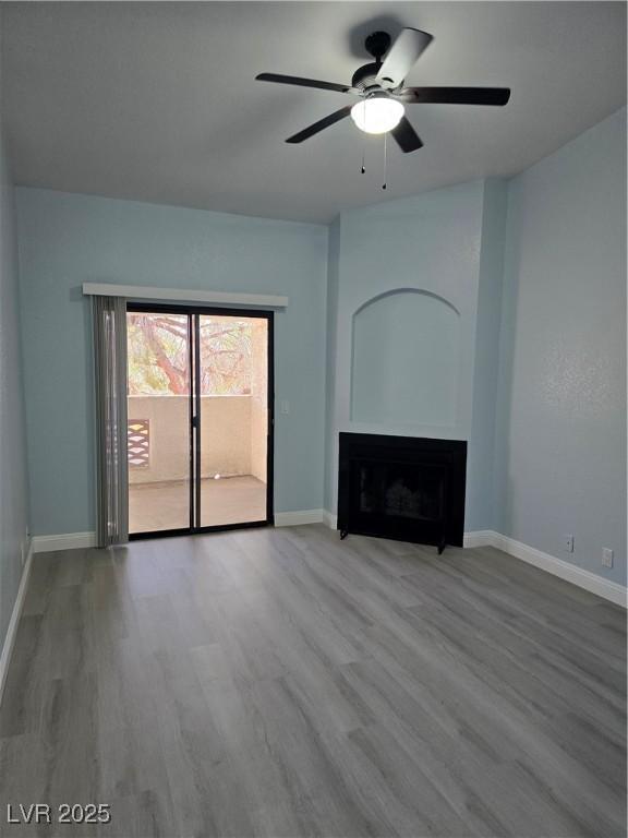 unfurnished living room with hardwood / wood-style flooring and ceiling fan