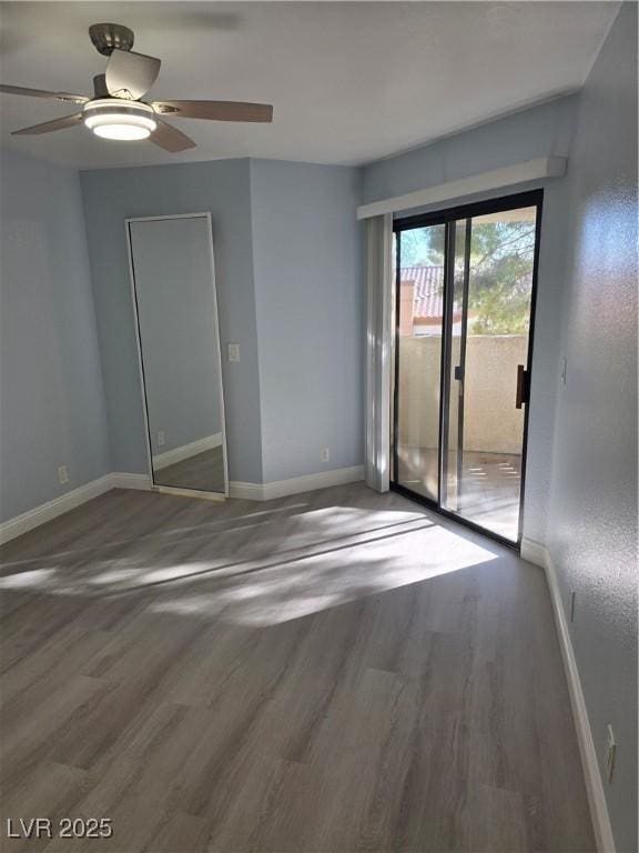 spare room with dark wood-type flooring and ceiling fan