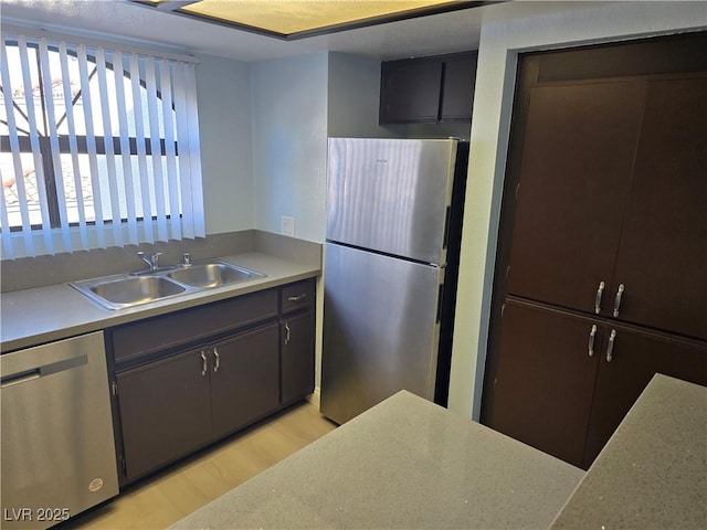 kitchen featuring appliances with stainless steel finishes, light hardwood / wood-style floors, and sink