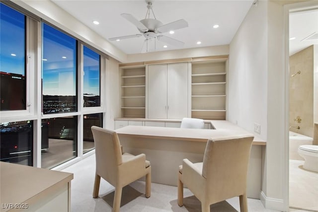 home office with built in shelves and ceiling fan