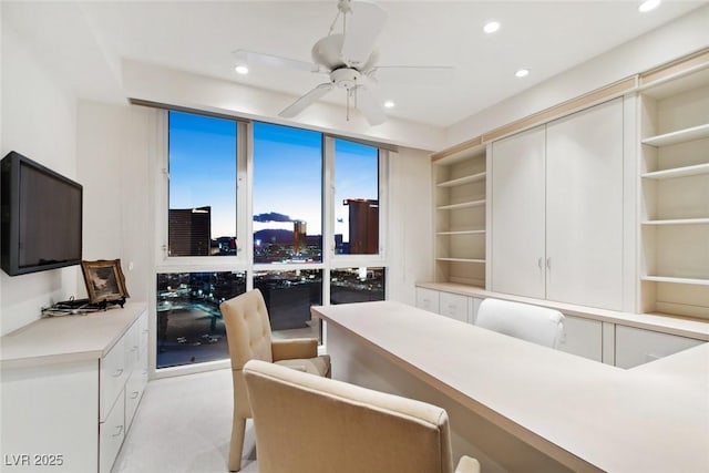 office with ceiling fan, built in features, and a wall of windows