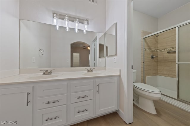 bathroom featuring walk in shower, vanity, toilet, and hardwood / wood-style floors